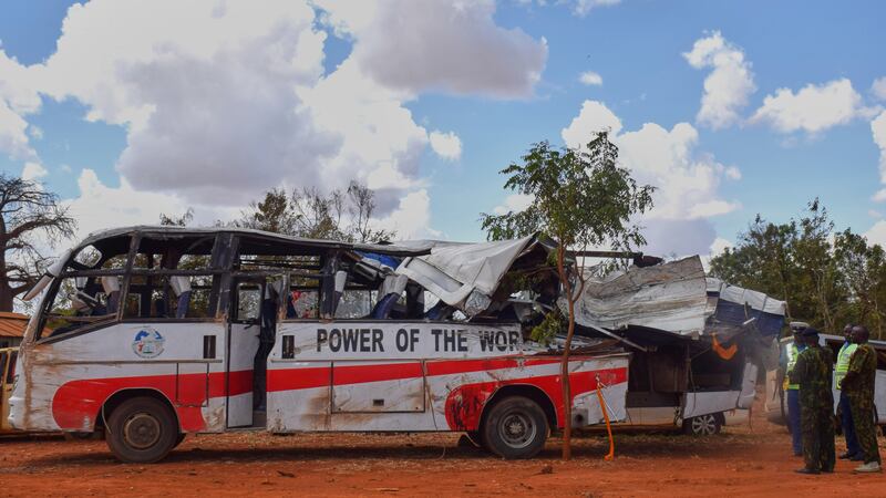 Policías observan un autobús accidentado en la autopista Nairobi-Mombasa estacionado en una...