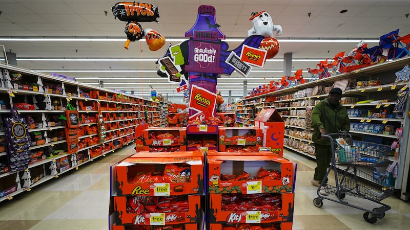 Un cliente camina junto a un estante de dulces de Halloween en una tienda Giant, el jueves 22...