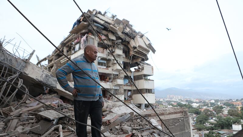 Un hombre permanece de pie entre los escombros de un edificio derrumbado tras un terremoto en...