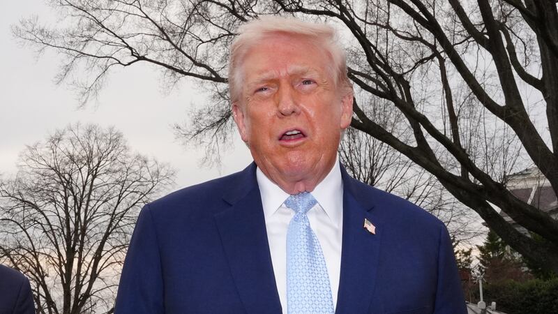 President Donald Trump speaks with reporters before departing on Marine One from the South...