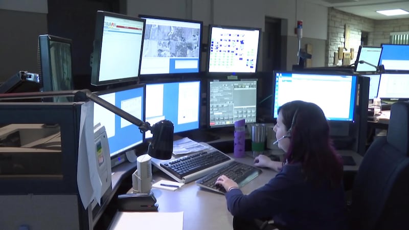 911 dispatcher looking at computer monitors
